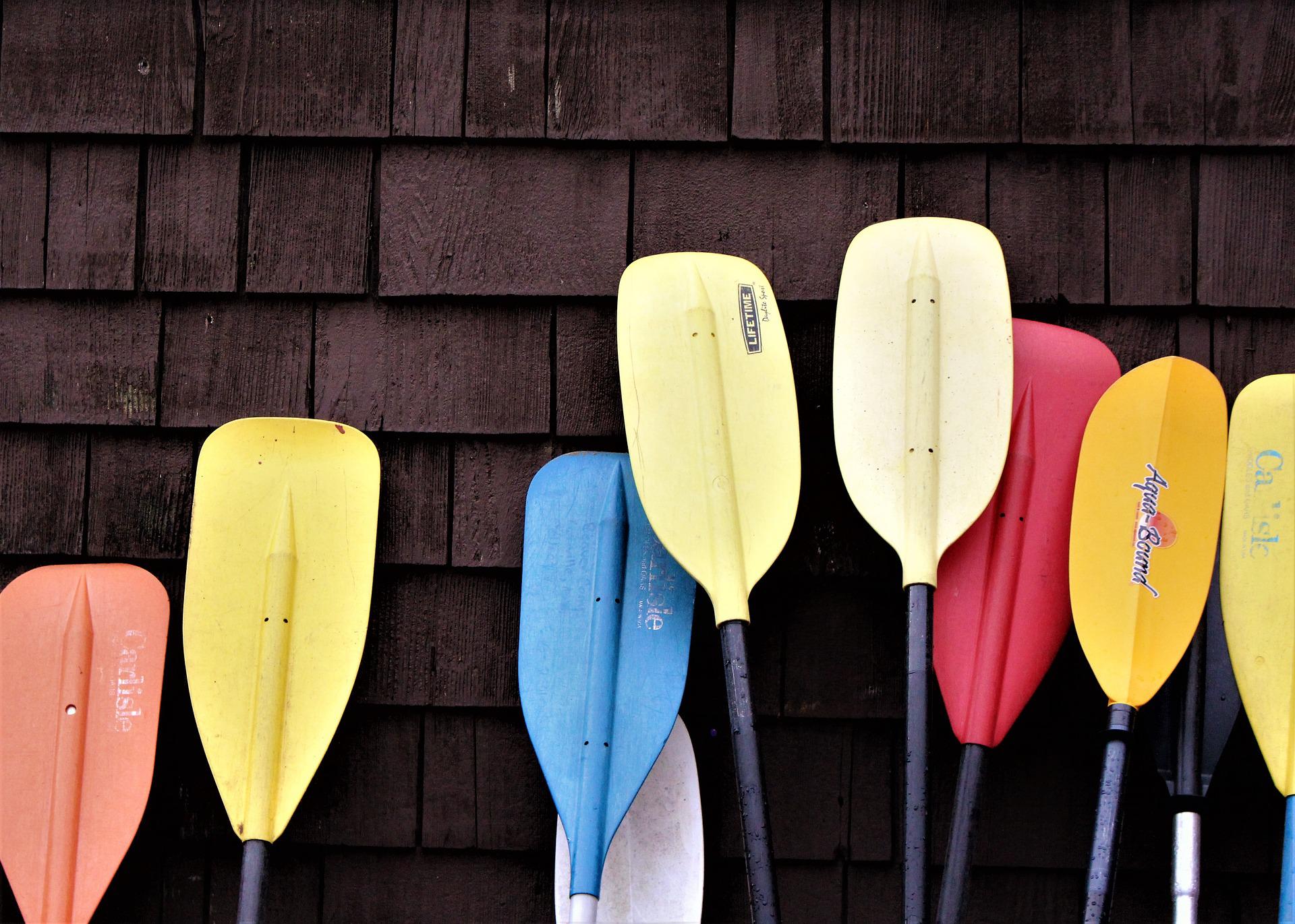 Colorful paddles leaning against a wall.