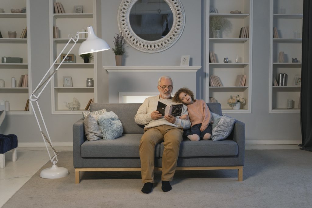Grandfather reading to a young girl.